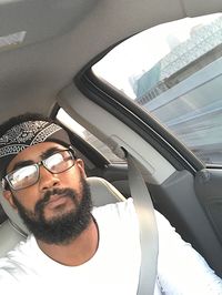 Portrait of young man sitting in car