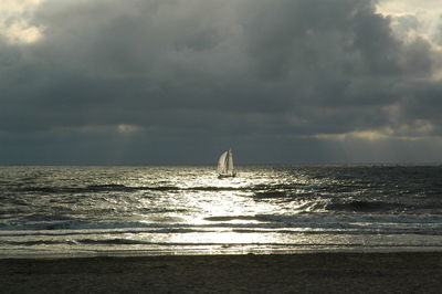 Scenic view of beach against cloudy sky