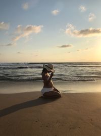 Full length of man on beach against sky during sunset