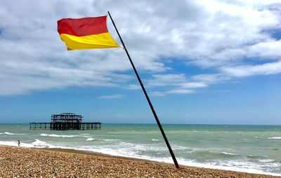 Flag on beach against sky