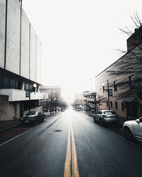 Cars on road in city against clear sky