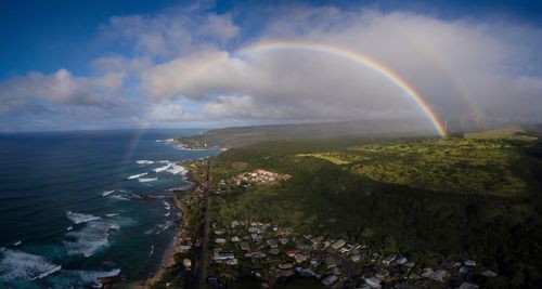 Scenic view of rainbow over sea against sky