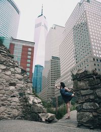 Man standing by modern buildings in city