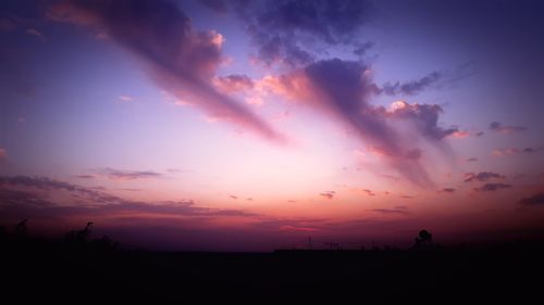 Scenic view of silhouette field against sky during sunset