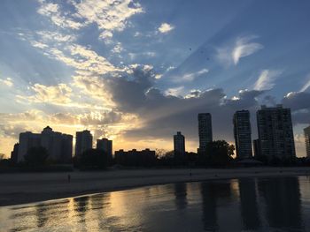 Buildings in city against sky during sunset