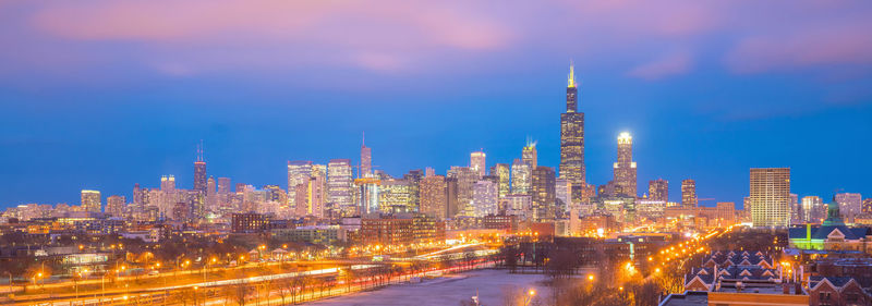 Illuminated buildings against sky at night