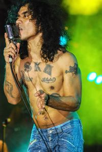 Full length of shirtless man standing against wall