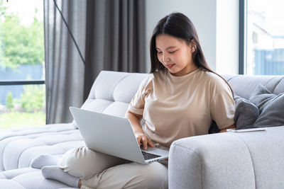 Young woman using laptop at home