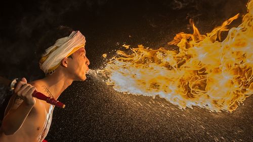 Side view of fire-eater over black background