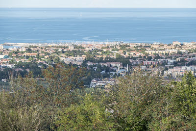 High angle view of townscape by sea against sky