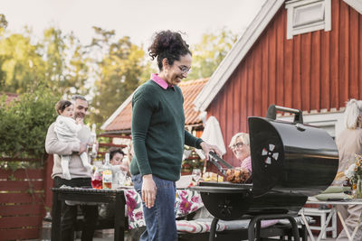 Smiling woman preparing food on barbecue