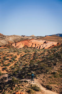 Female hiker walking through the landscape of the desert