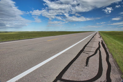 Road by landscape against sky