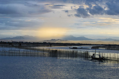 Scenic view of river against sky at sunset