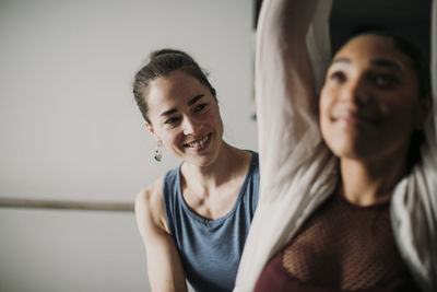 Smiling personal trainer helps her female client with fitness