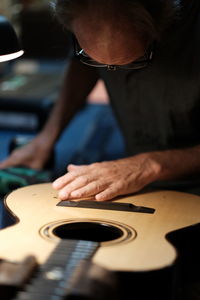 Midsection of man playing guitar