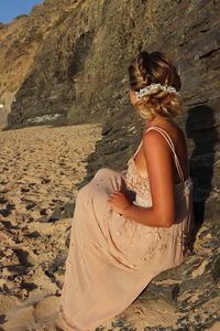 Woman sitting on rock at beach