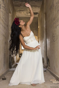 Young woman standing against wall