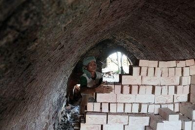 Man arranging bricks in tunnel