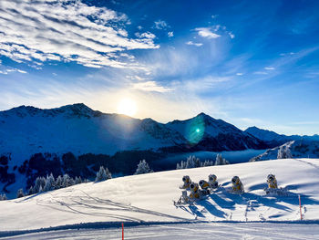 View to the impressive winter landscape with mountains, fresh snow, sunshine and snow cannons