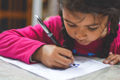 Close-up of girl making face on table