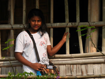 Portrait of a bengali girl standing against window 