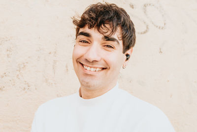 Close-up portrait of young man against wall