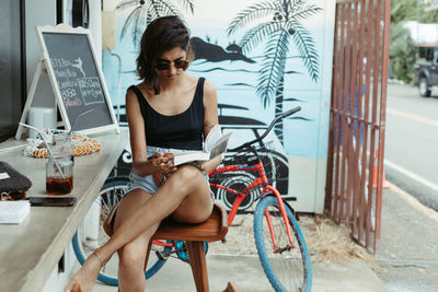 Full length of woman sitting on bicycle