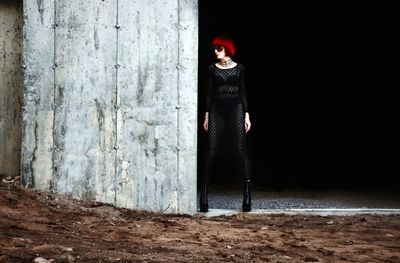 Full length of fashionable mature woman standing on abandoned door