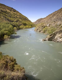 Scenic view of river amidst mountains against clear sky
