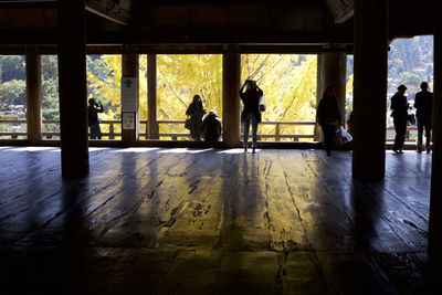 Silhouette people sitting in window