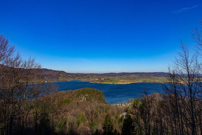 Scenic view of lake against clear blue sky