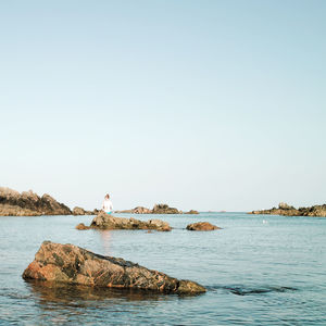 Rocks at sea against sky