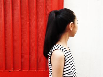 Woman standing by red door