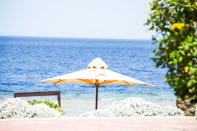 Umbrella on beach against clear sky