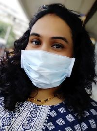 Close-up portrait of a beautiful young woman covering face