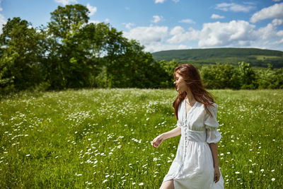 Side view of young woman standing on field