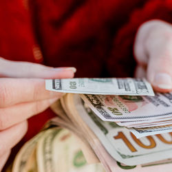 Midsection of woman holding paper currency