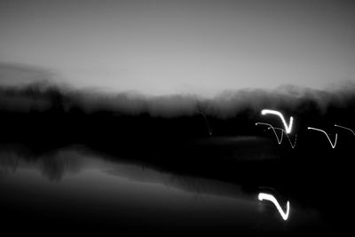 Scenic view of lake against sky at night