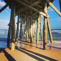 Pier on sea against sky during sunset