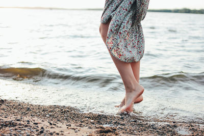 Low section of woman standing on beach