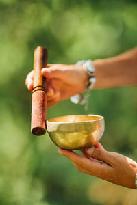 Hands of a woman playing tibetan singing bowl in nature