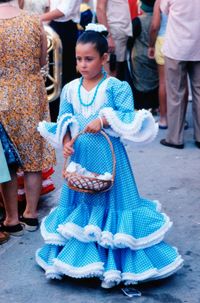 Full length of girl in traditional clothing holding basket while walking on street