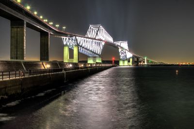 Illuminated bridge against sky at night