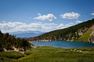 Scenic view of lake and mountains against blue sky