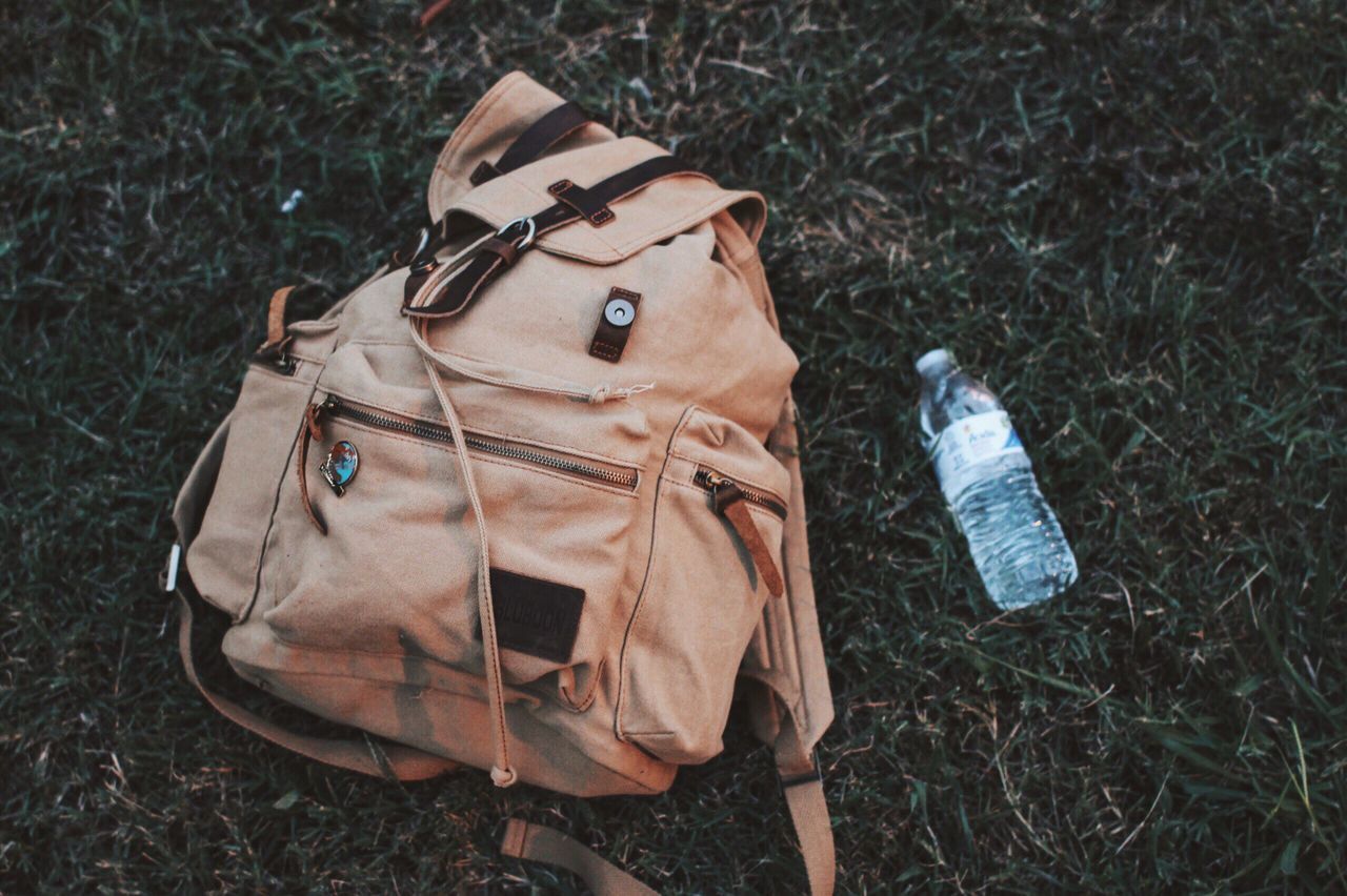 HIGH ANGLE VIEW OF LEATHER BAG ON FIELD