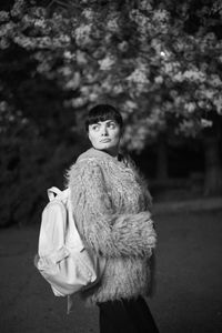 Portrait of woman with toy standing in park
