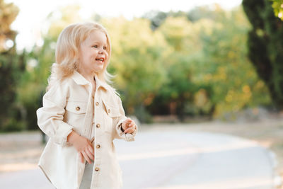 Portrait of young woman standing on road