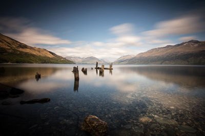 View of wooden poles in calm water