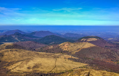 Scenic view of mountains against blue sky